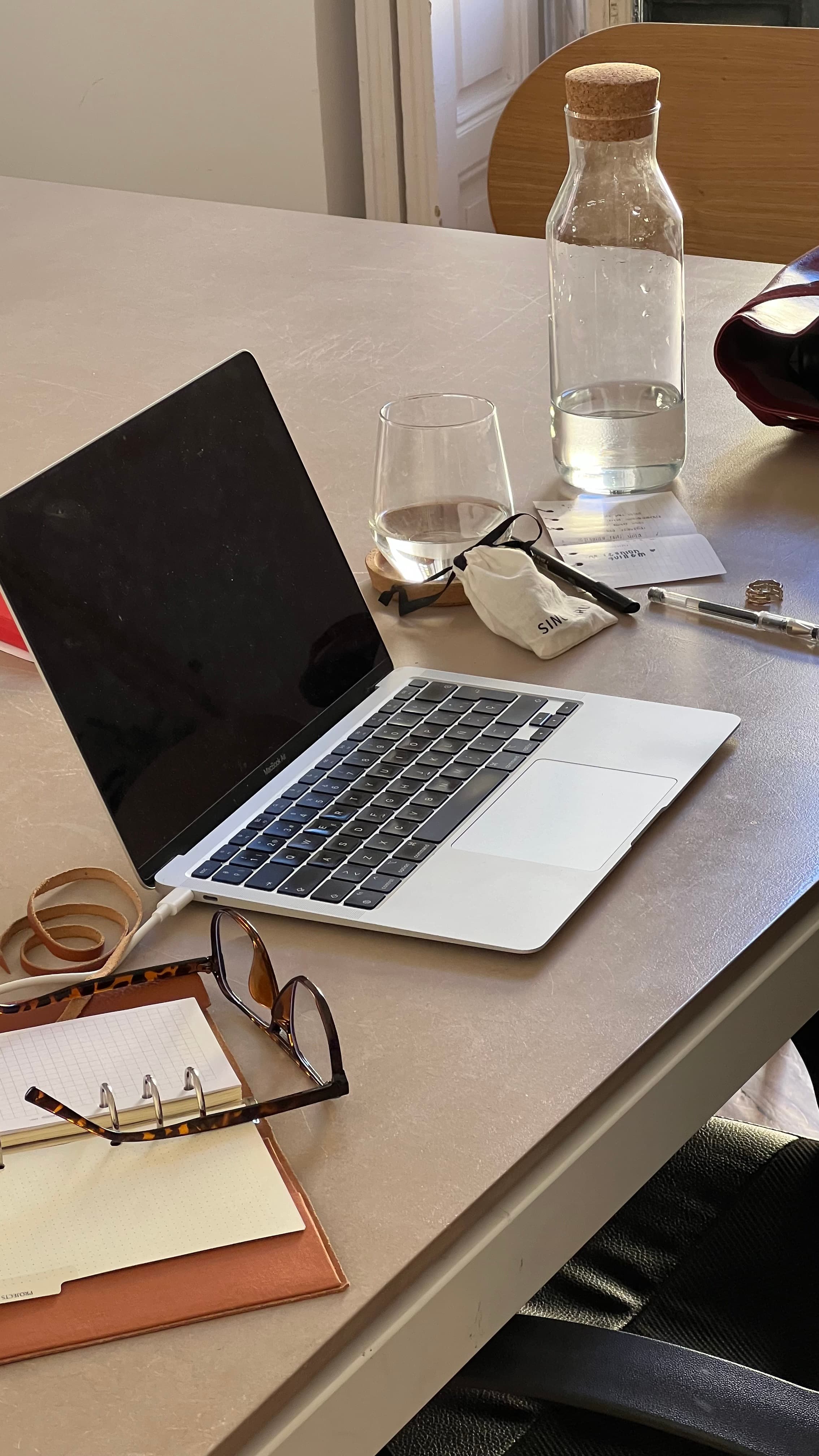 A laptop, notebook, and glasses on a desk during a workplace review session